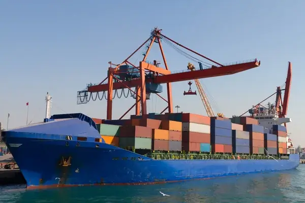 Porte-conteneurs bleu à quai sous une grue portuaire
